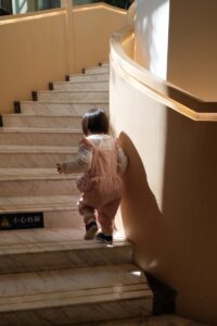A little girl walking down a set of stairs