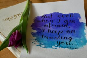 a purple flower sitting on top of a piece of paper